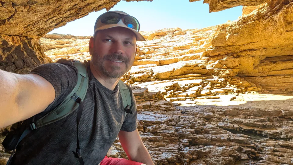 Felipe exploring sunlit rock formations in Greece.