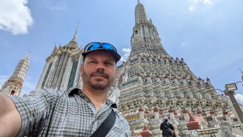 Felipe in front of an ornate temple in Thailand.