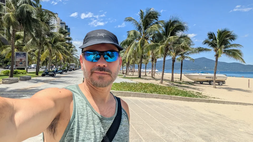 Felipe beside a palm-lined beach in Vietnam.